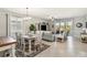 Open-concept living room with a dining table, shuttered windows, ceiling fan, and light blue furniture at 5165 Coral Reef Way, Bradenton, FL 34211