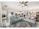 Bright open-concept living room with tile floors, ceiling fan, and furniture; open to kitchen and dining area at 5165 Coral Reef Way, Bradenton, FL 34211
