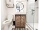 A stylish bathroom features a wooden vanity, modern fixtures, and a glass enclosed shower at 5307 47Th Street E Ct, Bradenton, FL 34203