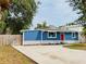 Charming blue home featuring a bright red door, stone accents, and a newly installed driveway at 5307 47Th Street E Ct, Bradenton, FL 34203