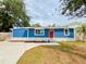 Charming blue home featuring a bright red door, stone accents, and a newly installed driveway at 5307 47Th Street E Ct, Bradenton, FL 34203