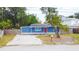 Charming single-story home boasts a red front door, blue siding and a well-manicured front yard at 5307 47Th Street E Ct, Bradenton, FL 34203