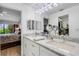 Bright bathroom featuring double sink with marble countertop and modern lighting fixture, with bedroom view at 5632 Ashton Lake Dr # 5632, Sarasota, FL 34231
