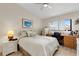 Comfortable bedroom with white furniture, ceiling fan, desk, and a sunlit window at 5632 Ashton Lake Dr # 5632, Sarasota, FL 34231