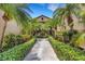 Inviting condo exterior featuring lush landscaping and palm trees lining the walkway to the entrance at 5632 Ashton Lake Dr # 5632, Sarasota, FL 34231