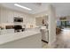 Stylish white kitchen with stainless steel appliances, quartz countertops, and a view to the living area at 5632 Ashton Lake Dr # 5632, Sarasota, FL 34231