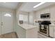 Well-lit kitchen with stainless steel appliances, white cabinets, and a breakfast bar for casual dining at 5632 Ashton Lake Dr # 5632, Sarasota, FL 34231