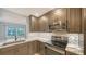 Updated kitchen with stainless steel appliances, grey cabinets, marble countertops, and herringbone backsplash at 5706 10Th Avenue Dr W, Bradenton, FL 34209
