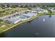 Aerial view shows Circle Woods clubhouse, community pool, and a serene lake with fountain at 577 Circlewood Dr # X7, Venice, FL 34293