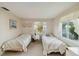 Bright bedroom with twin beds, carpeted floor and natural light at 577 Circlewood Dr # X7, Venice, FL 34293
