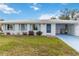 Charming single-story home featuring a bright blue door, light blue shutters, and a well-maintained front lawn at 577 Circlewood Dr # X7, Venice, FL 34293