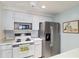 Functional kitchen with stainless steel refrigerator and white appliances, complemented by ample storage at 577 Circlewood Dr # X7, Venice, FL 34293