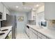 Well-lit kitchen with stainless steel appliances, white cabinets, and laminate countertops at 577 Circlewood Dr # X7, Venice, FL 34293