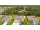 Aerial view of well-manicured home with a large driveway, colorful landscaping, and a community pond nearby at 5904 114Th E Dr, Parrish, FL 34219