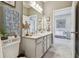 Bright bathroom featuring double sinks, gray cabinets, framed mirror, gray tile, and a decorative starfish at 5904 114Th E Dr, Parrish, FL 34219