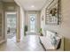 Elegant foyer with tile flooring, a decorative bench, and a view into the living spaces at 5904 114Th E Dr, Parrish, FL 34219