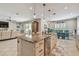 Open concept kitchen with large island, stainless appliances, and pendant lighting at 5904 114Th E Dr, Parrish, FL 34219