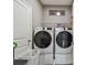 Well-equipped laundry room featuring a front loading washer and dryer, overhead rack and white folding basket at 5904 114Th E Dr, Parrish, FL 34219