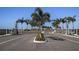 Community entrance with palm trees lining the street under a sunny blue sky at 659 Maldives Trl, Sarasota, FL 34234