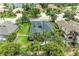 An aerial shows the house with a well-manicured lawn, mature landscaping, and fenced-in backyard at 6674 Coopers Hawk Ct, Lakewood Ranch, FL 34202