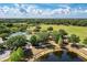 An aerial view showcasing a community park featuring a pool, playground, lake, and walking trail at 6674 Coopers Hawk Ct, Lakewood Ranch, FL 34202