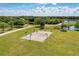 Aerial view of community park featuring a basketball court, walking path, lush trees, and a scenic pond at 6674 Coopers Hawk Ct, Lakewood Ranch, FL 34202