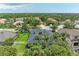 Aerial view of a neighborhood showcasing mature trees, ponds, luxury homes, and lush green landscaping at 6674 Coopers Hawk Ct, Lakewood Ranch, FL 34202