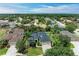 Aerial view of a landscaped single-Gathering home featuring mature trees, a well-manicured lawn, and a 2-car garage at 6674 Coopers Hawk Ct, Lakewood Ranch, FL 34202