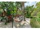 Outdoor lounging features a hammock nestled among lush greenery and tropical landscaping for relaxation at 6674 Coopers Hawk Ct, Lakewood Ranch, FL 34202