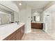 Bright bathroom with double vanity, modern mirrors, quartz countertops, and walk-in shower at 6674 Coopers Hawk Ct, Lakewood Ranch, FL 34202