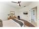 This bedroom features wood floors, ceiling fan, and mounted TV, with a dresser and mirror at 6674 Coopers Hawk Ct, Lakewood Ranch, FL 34202