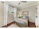 Bedroom showcasing wood floors, large window, and a cozy gray bed at 6674 Coopers Hawk Ct, Lakewood Ranch, FL 34202