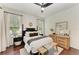 Cozy bedroom boasts wood floors, modern furnishings, and bright natural light at 6674 Coopers Hawk Ct, Lakewood Ranch, FL 34202