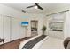 Cozy bedroom with dark wood floors, double closets, and a view of the living area at 6674 Coopers Hawk Ct, Lakewood Ranch, FL 34202