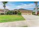 Attractive single-Gathering home with a manicured lawn, large driveway, three-car garage, and lush landscaping at 6674 Coopers Hawk Ct, Lakewood Ranch, FL 34202