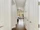 Hallway featuring wood floors and multiple doorways, leading to a light-filled living area at 6674 Coopers Hawk Ct, Lakewood Ranch, FL 34202