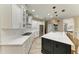 Modern kitchen with white cabinets, stainless steel appliances, and large island with bar seating at 6674 Coopers Hawk Ct, Lakewood Ranch, FL 34202