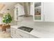 Close-up of the kitchen's stovetop, range hood, and elegant white cabinetry at 6674 Coopers Hawk Ct, Lakewood Ranch, FL 34202