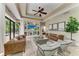 Spacious living room with tray ceiling, modern decor, and sliding glass doors to the pool area at 6674 Coopers Hawk Ct, Lakewood Ranch, FL 34202