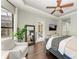 Spacious main bedroom featuring wood floors, a ceiling fan, and a view of the outdoor pool area at 6674 Coopers Hawk Ct, Lakewood Ranch, FL 34202
