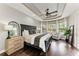 Serene main bedroom with tray ceilings, hardwood floors, and a seating area overlooking the lush backyard at 6674 Coopers Hawk Ct, Lakewood Ranch, FL 34202