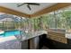 Poolside outdoor kitchen featuring a built-in grill, countertop, and bar seating for entertaining guests at 6674 Coopers Hawk Ct, Lakewood Ranch, FL 34202