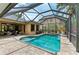 The screened-in pool area offers a relaxing outdoor space with ample seating and lush tropical landscaping at 6674 Coopers Hawk Ct, Lakewood Ranch, FL 34202