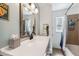 Neutral toned bathroom with a white countertop sink, wood-framed mirror, shower, and a decorative window at 6708 11Th Nw Ave, Bradenton, FL 34209