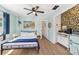 Cozy bedroom with light blue walls, hardwood floors, a queen-size bed, and a kitchenette with floral wallpaper at 6708 11Th Nw Ave, Bradenton, FL 34209
