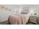 Bedroom with plank flooring is decorated with wall art, decorative pillows, and end tables with lamps at 6708 162Nd E Pl, Parrish, FL 34219