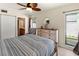Well-lit bedroom featuring a wooden dresser, cozy chair, and a view of the outdoors from the window at 6713 Midnight Pass Rd # 4, Sarasota, FL 34242