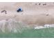 Aerial view of the sandy beach with clear aqua water and people relaxing on the beach at 7000 Gulf Dr # 205, Holmes Beach, FL 34217