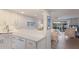 Open-concept kitchen with quartz countertop bar looking into dining and living area with beach view at 7000 Gulf Dr # 205, Holmes Beach, FL 34217