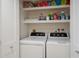 Convenient laundry area with washer and dryer, and shelves for storage of laundry supplies at 7000 Gulf Dr # 205, Holmes Beach, FL 34217